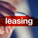Leasing, business concept - businesswoman highlighting word with red marker pen